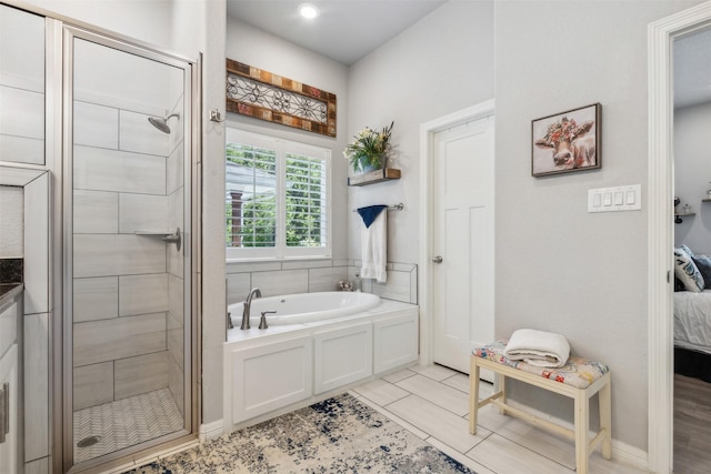 ensuite bathroom featuring ensuite bathroom, a stall shower, and a garden tub