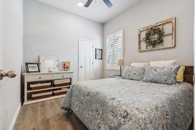 bedroom featuring ceiling fan, baseboards, and wood finished floors