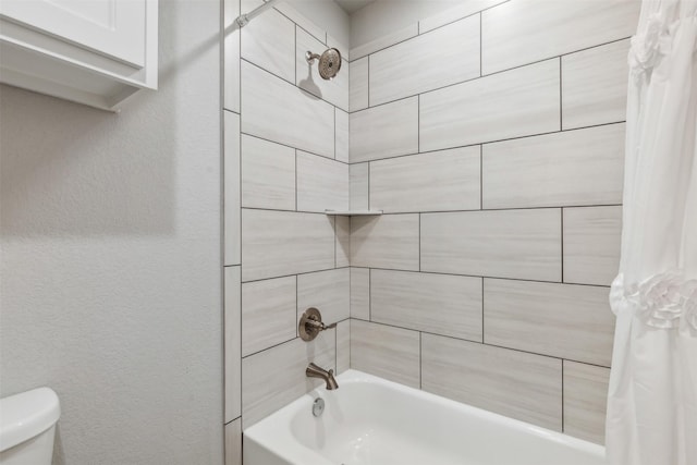 bathroom featuring a textured wall, toilet, and shower / bathtub combination with curtain