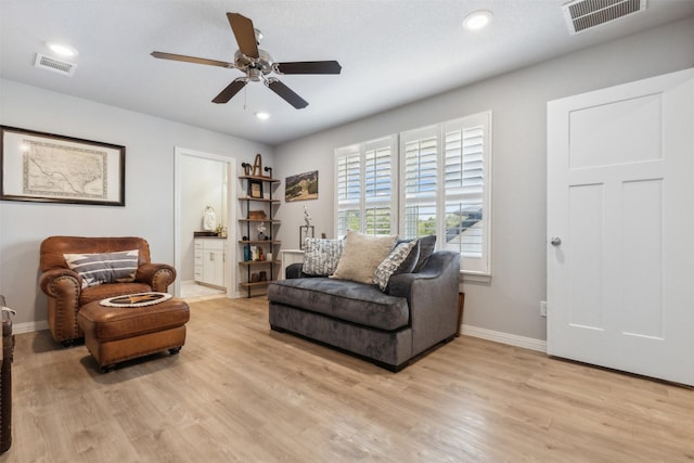 sitting room featuring light wood-type flooring, visible vents, and baseboards