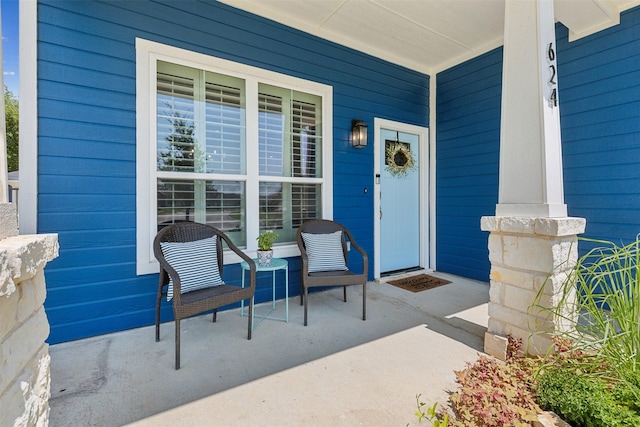 view of exterior entry featuring covered porch