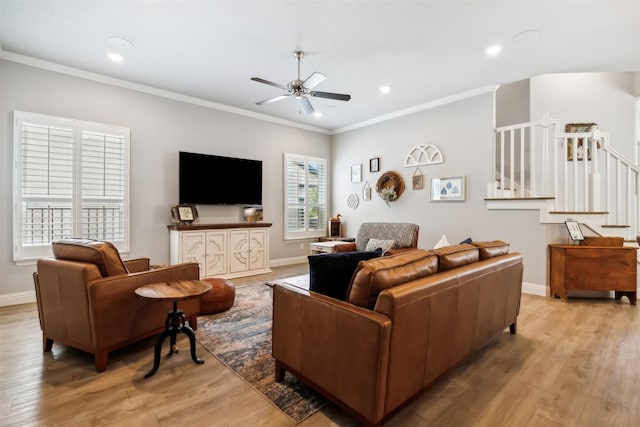 living area with ornamental molding, stairway, and light wood-type flooring