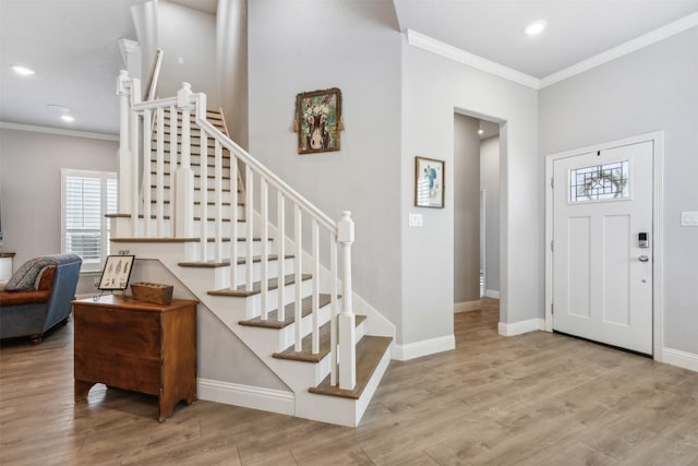 entryway featuring crown molding, wood finished floors, and baseboards