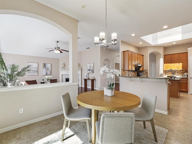 dining room with ceiling fan, light tile patterned flooring, recessed lighting, baseboards, and a tiled fireplace