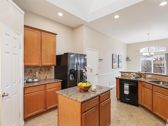 kitchen with a notable chandelier, tasteful backsplash, brown cabinetry, dark stone countertops, and black appliances