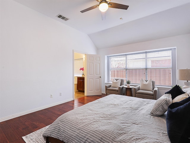 bedroom with baseboards, visible vents, lofted ceiling, hardwood / wood-style floors, and ensuite bathroom