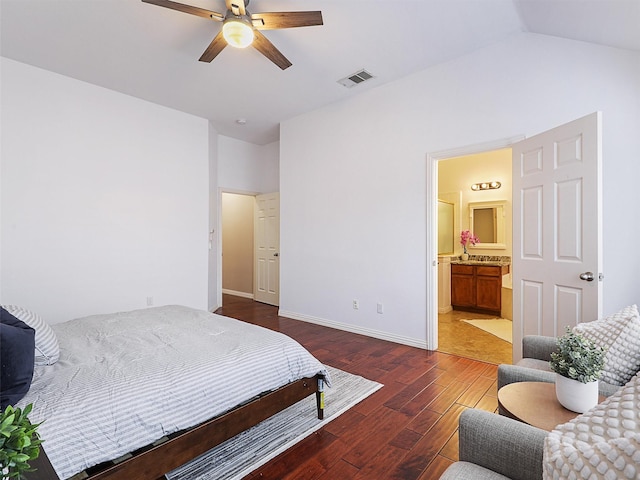 bedroom with visible vents, connected bathroom, vaulted ceiling, wood finished floors, and baseboards