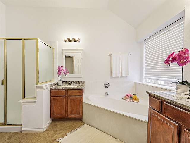 bathroom featuring lofted ceiling, a garden tub, vanity, a shower stall, and tile patterned floors