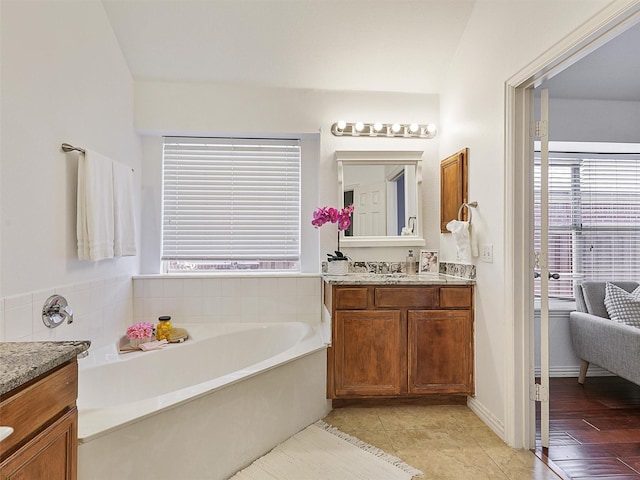 full bathroom featuring a bath, vanity, and tile patterned floors