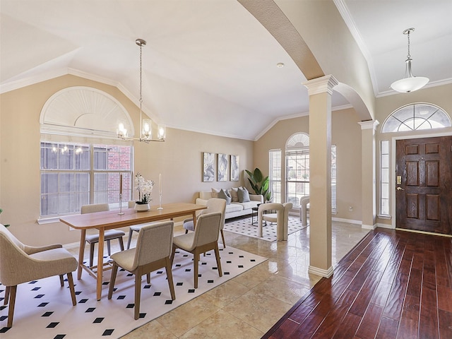 dining room featuring decorative columns, crown molding, vaulted ceiling, and wood finished floors