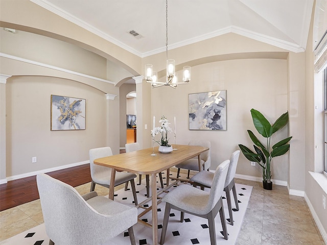 dining space with baseboards, visible vents, arched walkways, ornamental molding, and an inviting chandelier