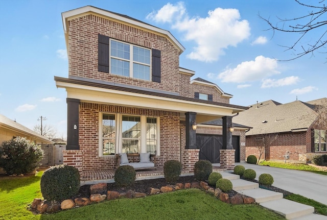 view of front of house featuring driveway, a garage, a porch, and brick siding