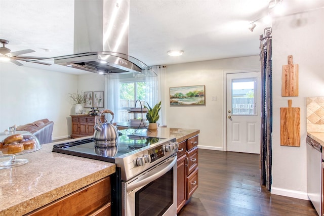 kitchen featuring dark wood-style flooring, brown cabinets, light countertops, appliances with stainless steel finishes, and island range hood