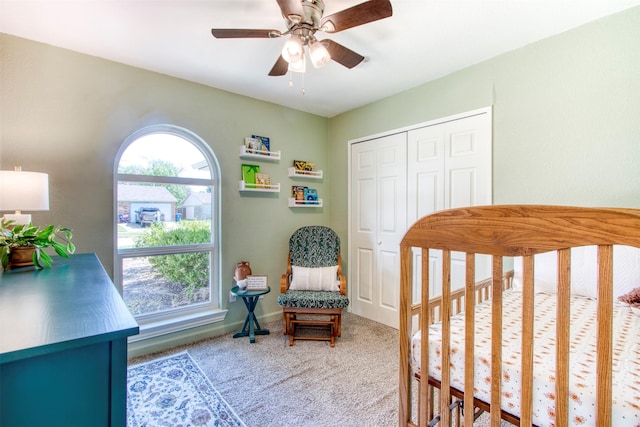 bedroom with light carpet, ceiling fan, baseboards, and a closet