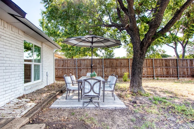 view of yard featuring outdoor dining area, a patio area, and a fenced backyard