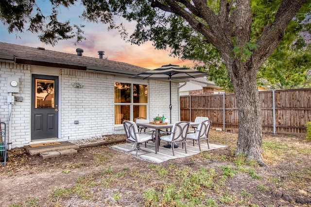 rear view of property with a patio, brick siding, and fence