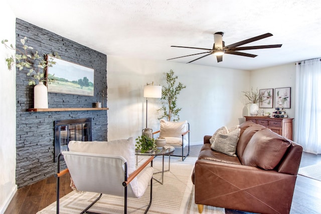 living area featuring a fireplace, wood finished floors, a ceiling fan, and baseboards