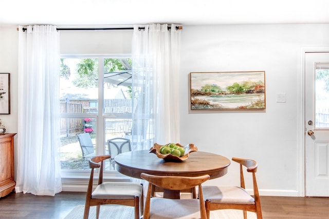 dining space with a healthy amount of sunlight, baseboards, and wood finished floors