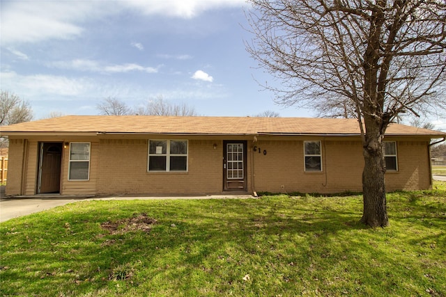 ranch-style home featuring brick siding and a front yard