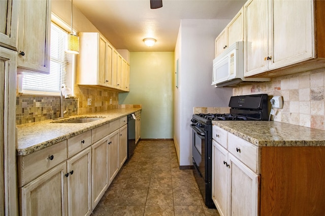 kitchen featuring dark tile patterned flooring, a sink, baseboards, black appliances, and tasteful backsplash