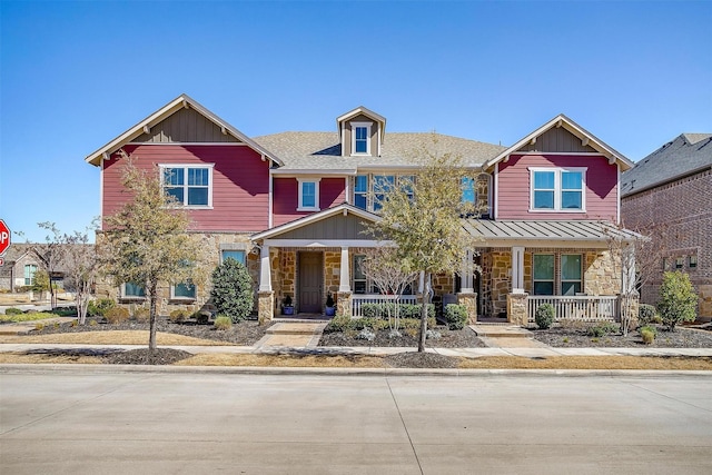 craftsman-style home featuring stone siding, metal roof, a standing seam roof, a porch, and board and batten siding