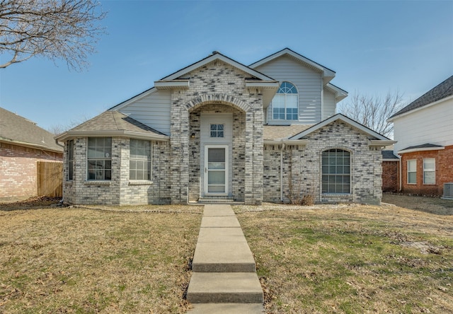 view of front of property with brick siding, a front yard, and a shingled roof