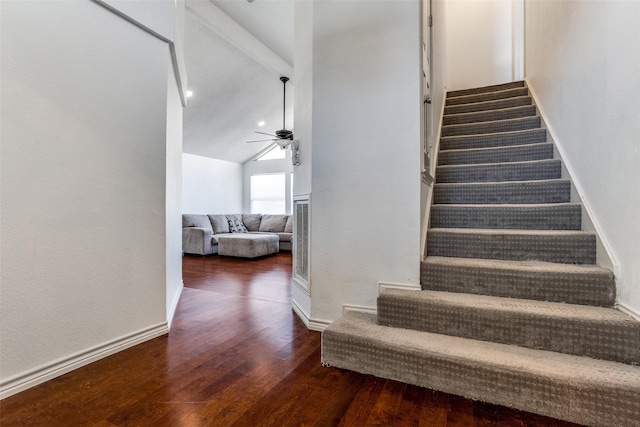 stairs featuring ceiling fan, hardwood / wood-style floors, vaulted ceiling, and baseboards