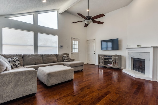 living area featuring ceiling fan, high vaulted ceiling, a fireplace, beam ceiling, and wood-type flooring