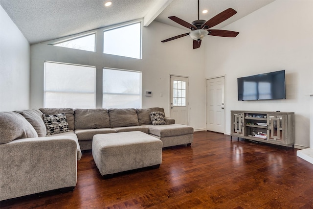 living area featuring ceiling fan, beam ceiling, baseboards, and wood finished floors