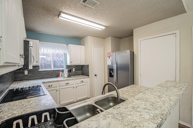 kitchen with visible vents, white cabinets, stainless steel appliances, light countertops, and backsplash