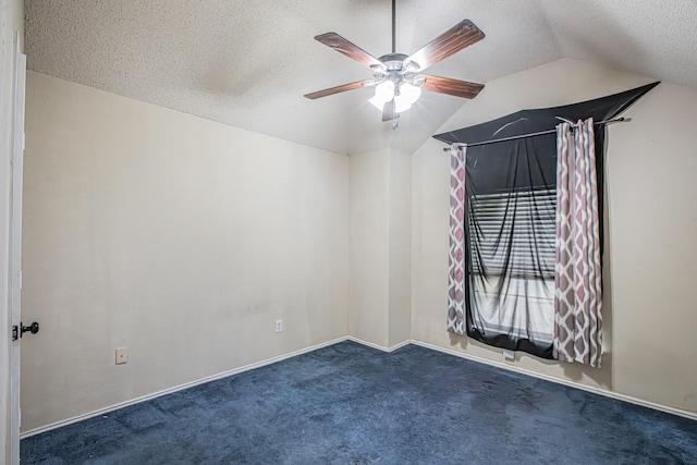 carpeted empty room with vaulted ceiling, a textured ceiling, and a ceiling fan