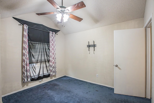 spare room featuring carpet floors, lofted ceiling, a textured ceiling, and a ceiling fan