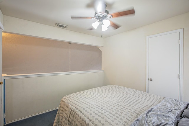 bedroom with a ceiling fan, dark colored carpet, and visible vents