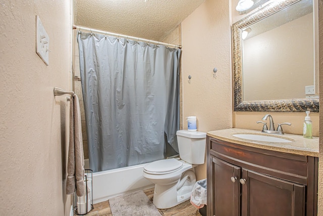 bathroom featuring a textured wall, toilet, shower / bath combo, a textured ceiling, and vanity