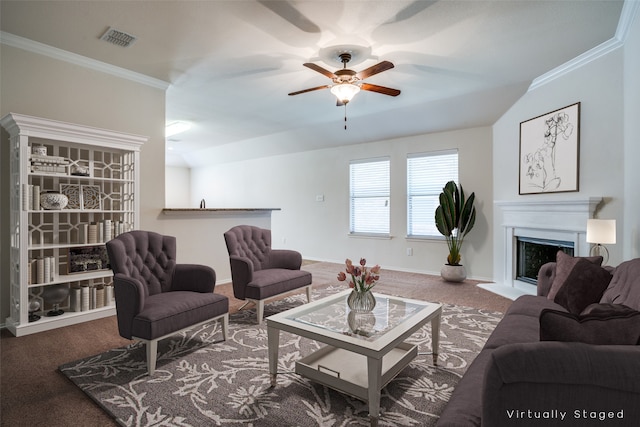 carpeted living area featuring crown molding, a fireplace, ceiling fan, and visible vents