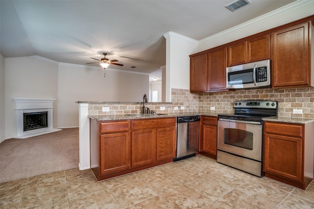kitchen featuring visible vents, stainless steel appliances, brown cabinetry, and a sink