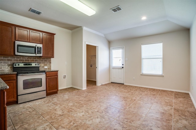 kitchen featuring dark stone countertops, visible vents, ornamental molding, and appliances with stainless steel finishes