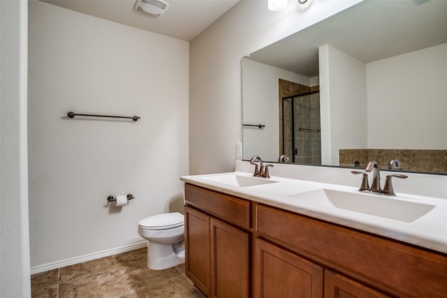 full bathroom featuring double vanity, a stall shower, a sink, and toilet