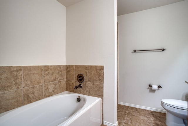 bathroom with a garden tub, toilet, and baseboards