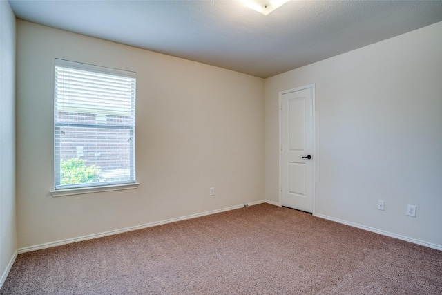 carpeted spare room with baseboards