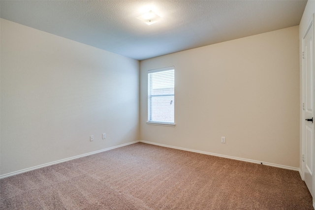 carpeted spare room featuring baseboards