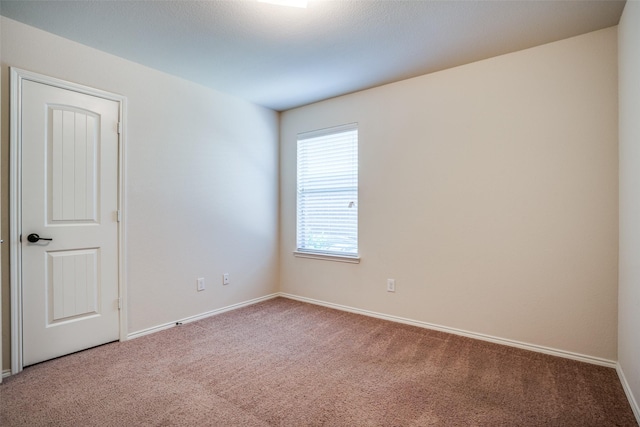 carpeted spare room with baseboards