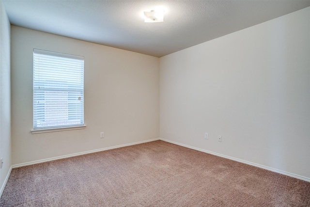 carpeted empty room with baseboards
