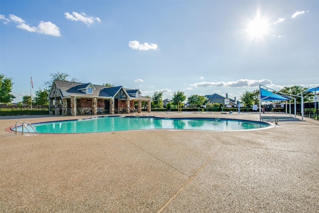 pool with a patio area and fence