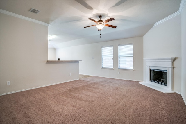 unfurnished living room with a fireplace with raised hearth, ornamental molding, carpet flooring, and visible vents