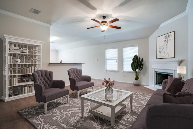 living room with ornamental molding, ceiling fan, a fireplace, and carpet