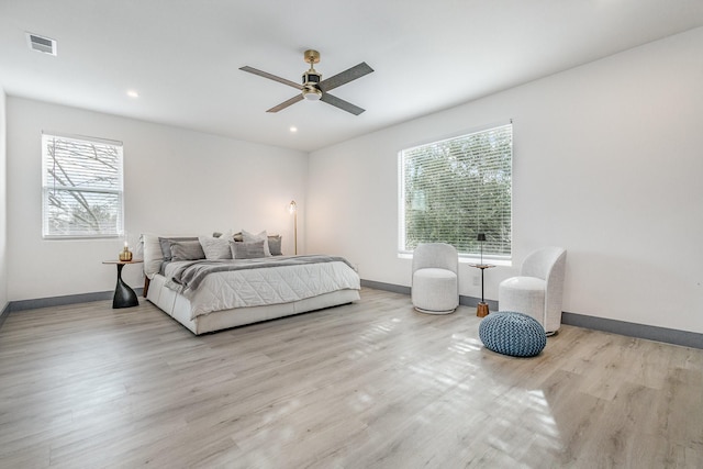 bedroom with visible vents, baseboards, and wood finished floors