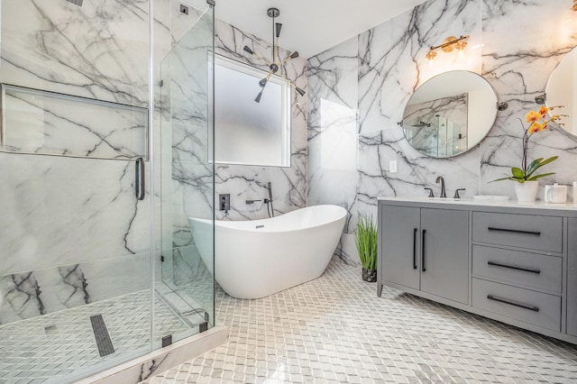 full bathroom featuring a freestanding tub, a marble finish shower, stone wall, and vanity