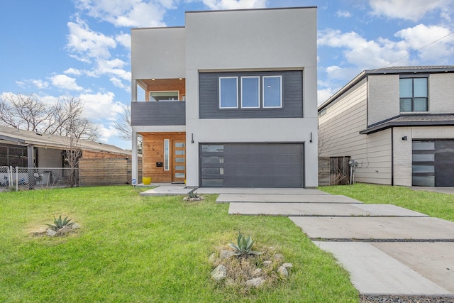 modern home with fence, stucco siding, a front lawn, concrete driveway, and a garage