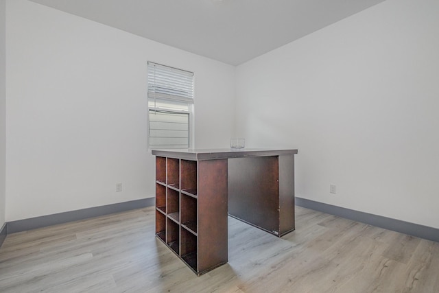 unfurnished office featuring light wood-style floors and baseboards